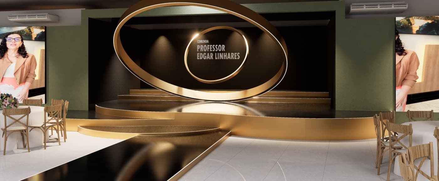 Palco da premiação com o grande anel dourado da Comenda Professor Edgar Linhares ao fundo e o salão preparado para o jantar.