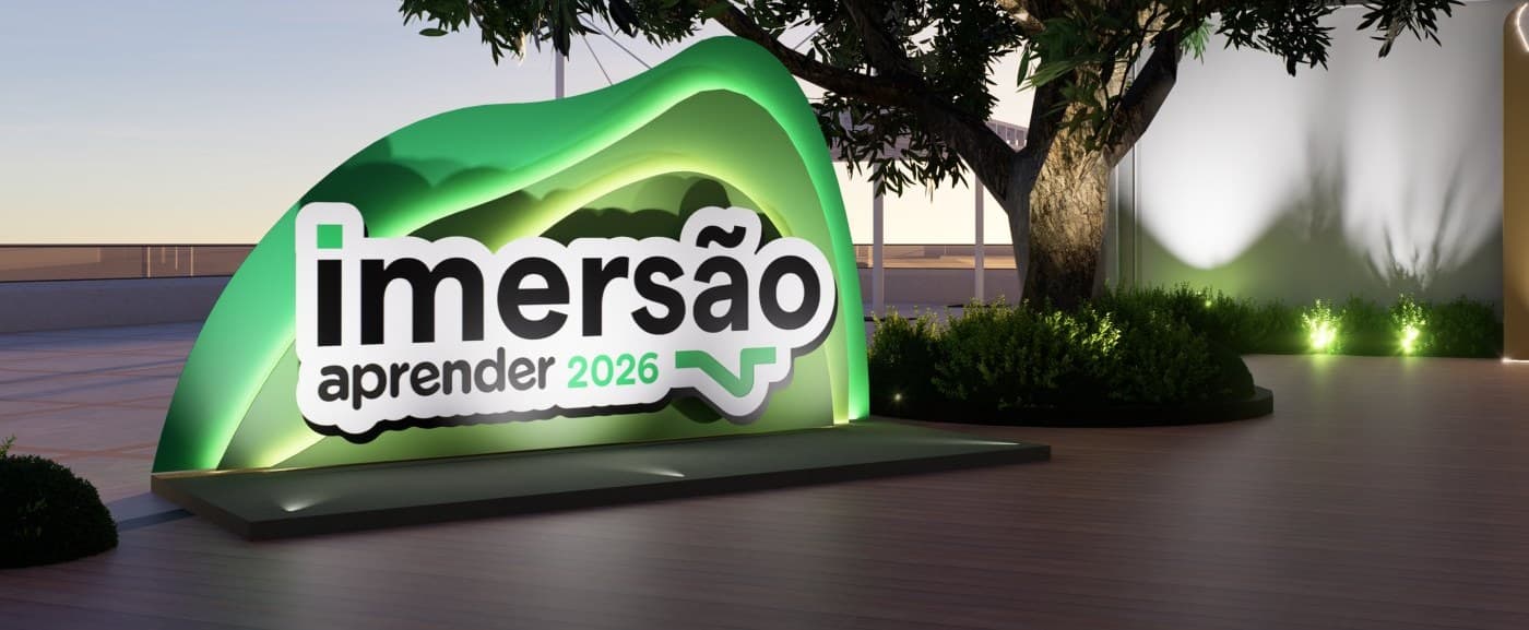 Monumento de entrada da Imersão Aprender 2026 iluminado ao entardecer, com o logotipo em relevo sobre uma base verde.